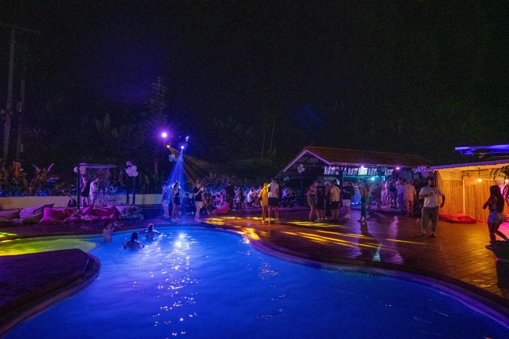 Un grupo de personas en una piscina por la noche. en Base Party Hostel, en Ao Nang Beach