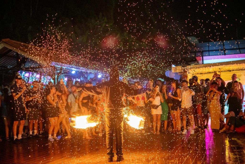 a group of people standing on a street with sparklers at Base Party Hostel in Ao Nang Beach