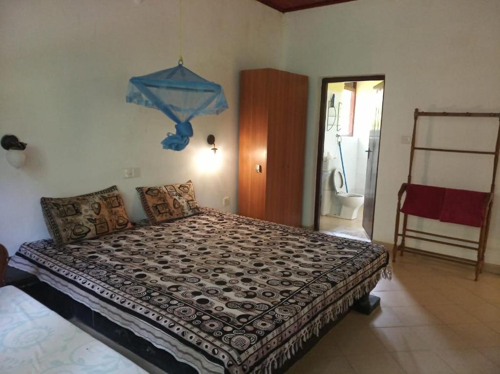 Lagoon Apartments Beruwala في بيرووالا: غرفة نوم مع سرير مع قطعة زرقاء على الحائط