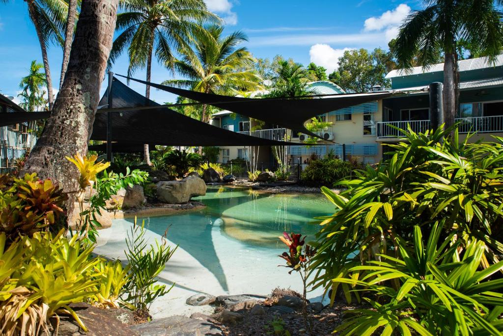 una piscina frente a un edificio con palmeras en Marlin Cove Holiday Resort, en Trinity Beach