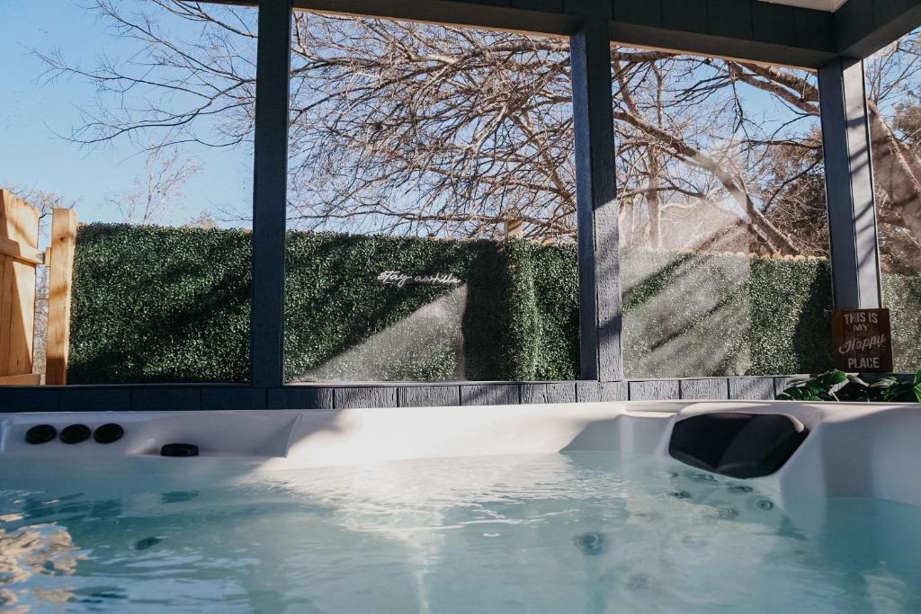 a jacuzzi tub in front of a window at Creed's Cottage at Four Oaks in New Braunfels
