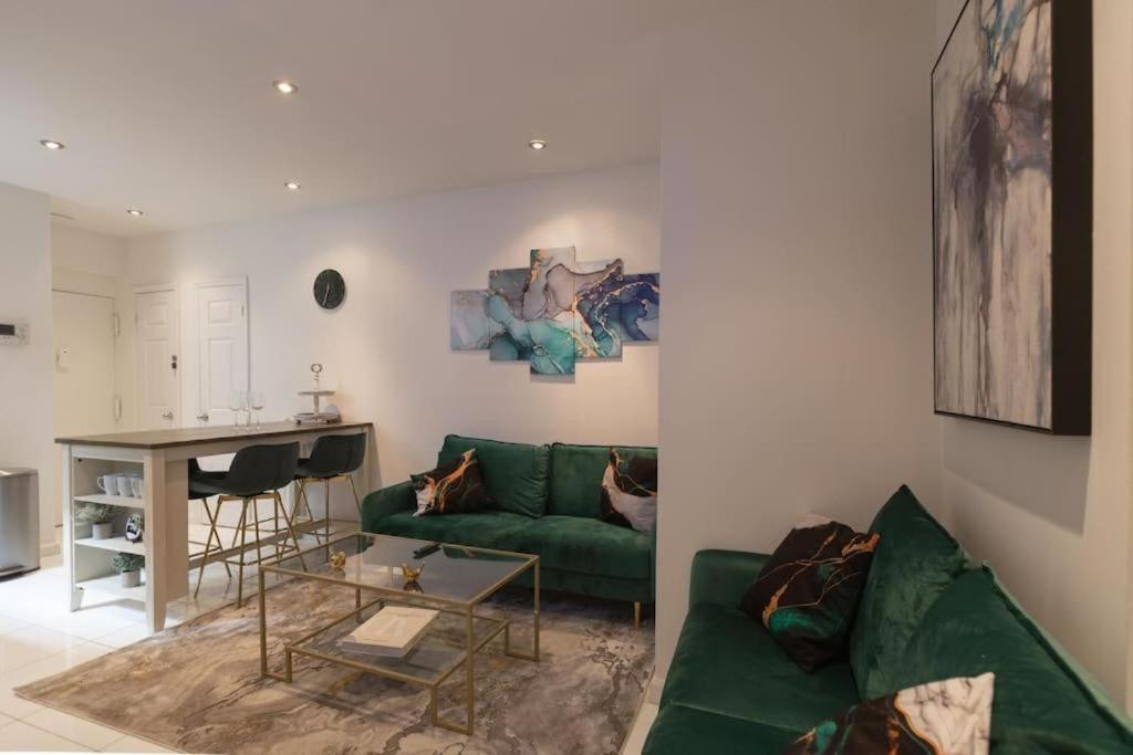 a living room with a green couch and a table at Stylish 5 Bedroom Apt in NYC! in New York