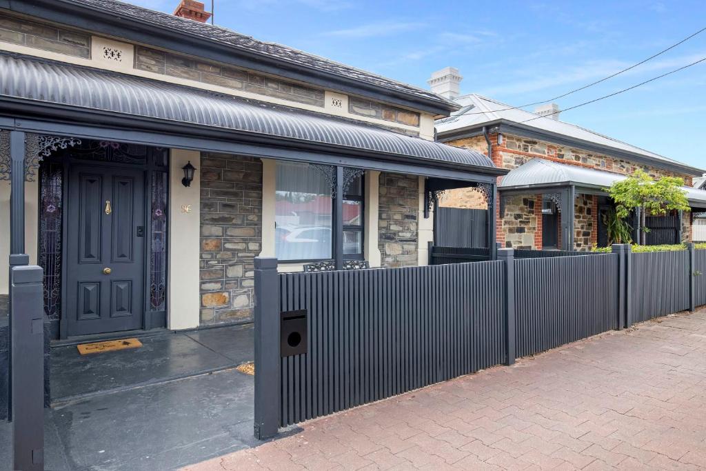 a house with a fence in front of it at Beach & Pines Glenelg in Glenelg