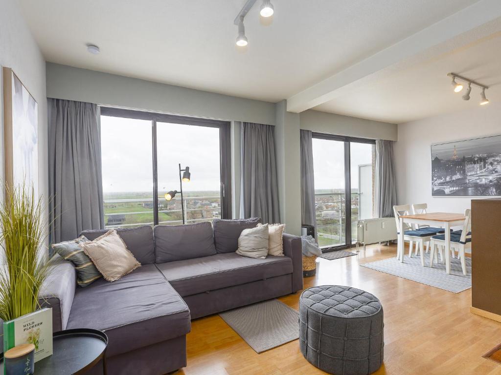 een woonkamer met een bank en een tafel bij Apartment on the 8th floor with terrace in Middelkerke