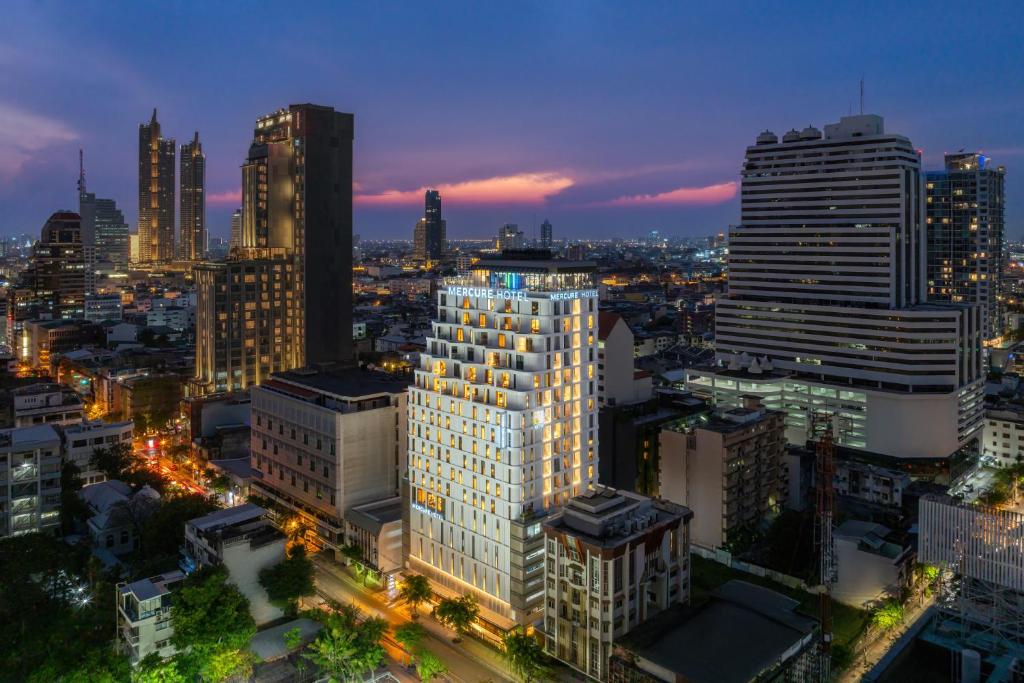 a view of a city skyline at night at Mercure Bangkok Surawong in Bangkok