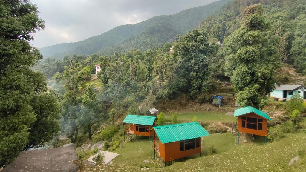 2 cottages sur le côté d'une montagne dans l'établissement Trekking Cougars Huts, à Dharamshala