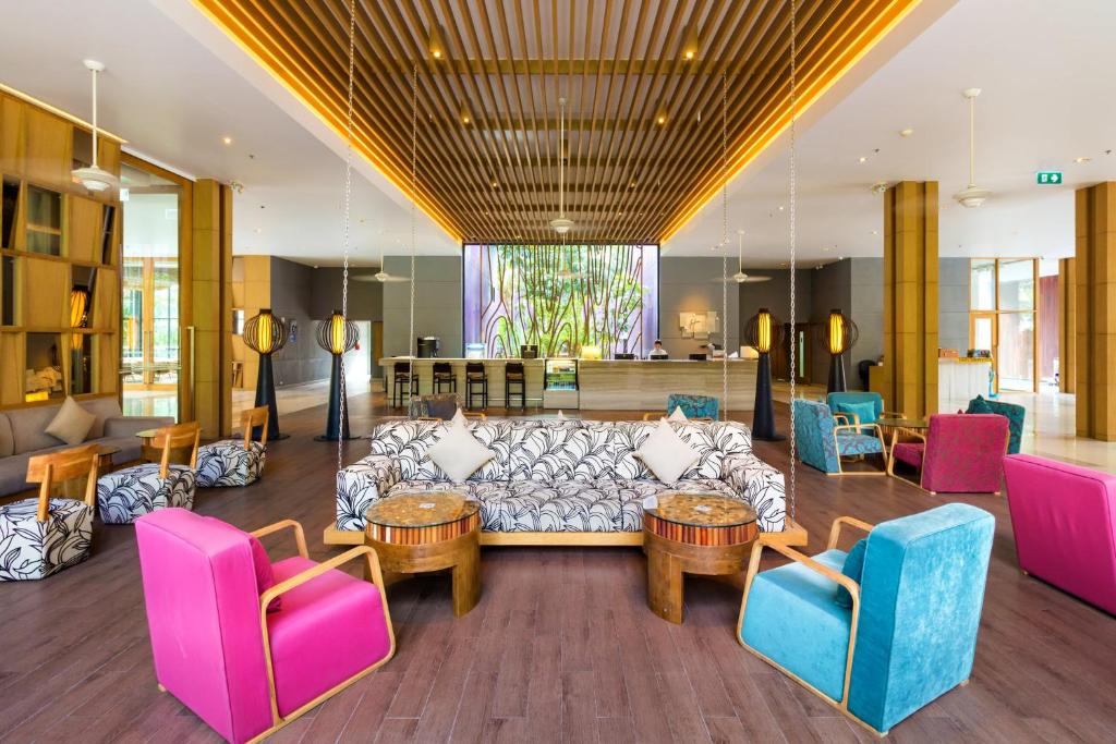a living room with a couch and tables and chairs at Holiday Inn Express Phuket Patong Beach Central, an IHG Hotel in Patong Beach