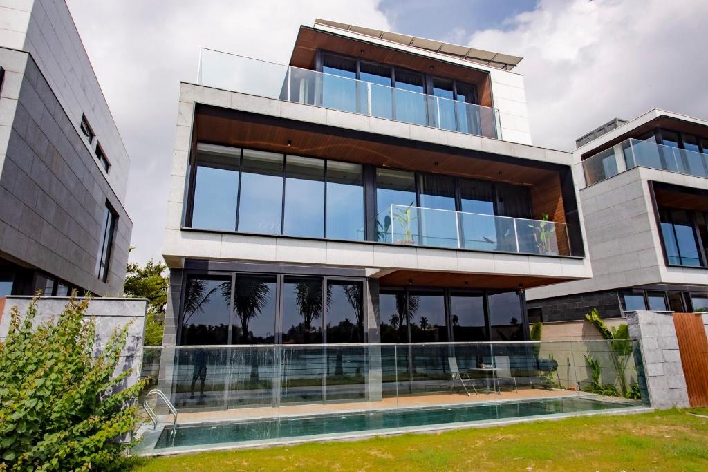um grande edifício com janelas de vidro e uma piscina em LUXURY VILLA with 5 BEDROOMS RIVER VIEW em Da Nang