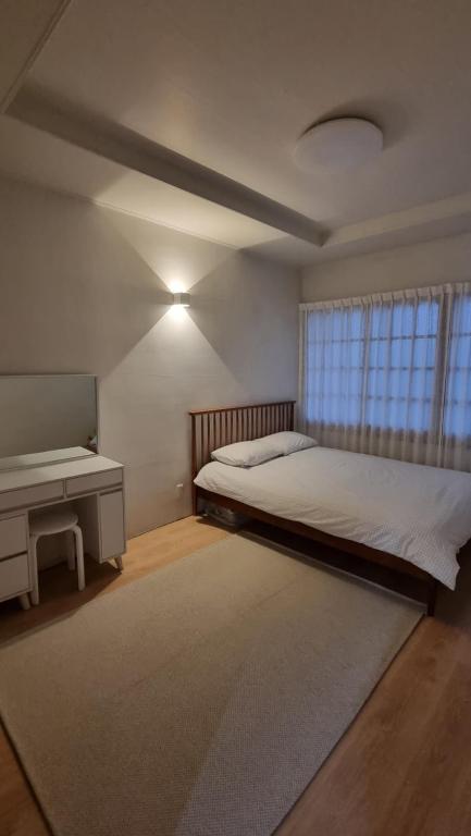 - une chambre avec un lit, un bureau et une fenêtre dans l'établissement Stay be oom, à Jeju
