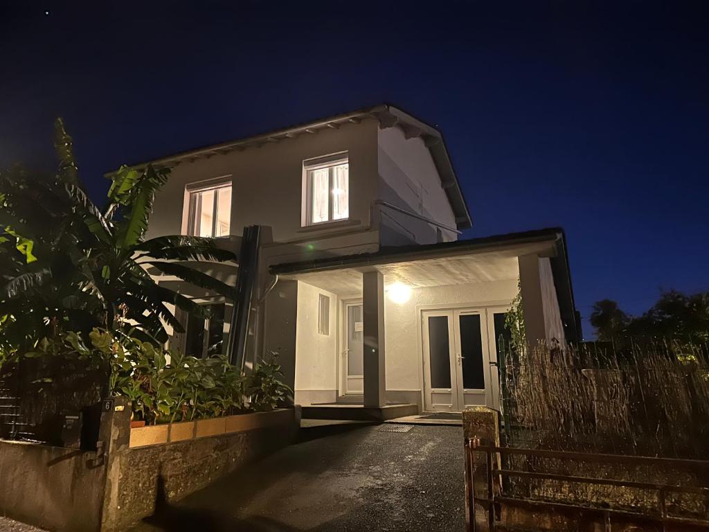 une maison blanche avec une clôture la nuit dans l'établissement Villa des palmiers, à Villeneuve-sur-Lot