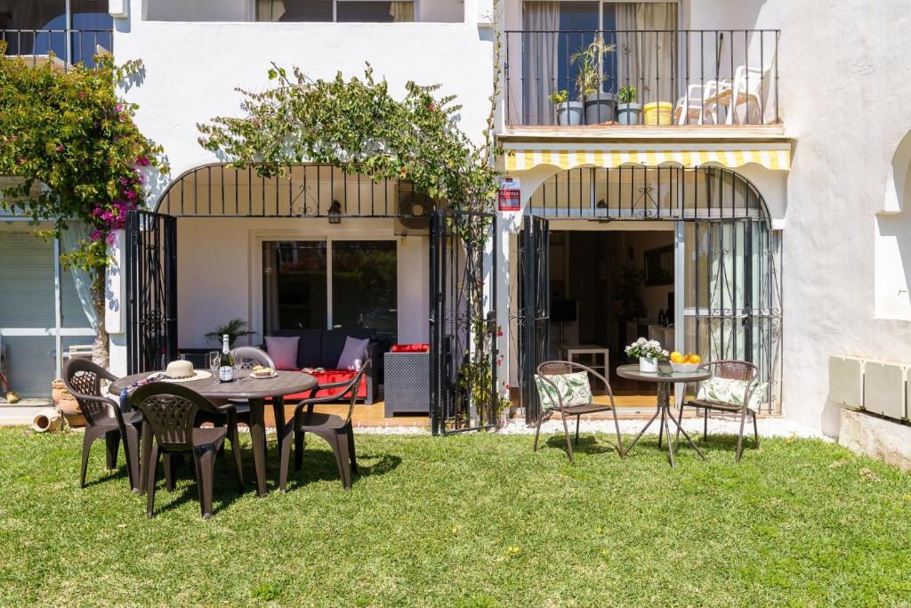 patio ze stołem i krzesłami na trawie w obiekcie Sunny Zoco Calahonda - Happy Rentals w mieście Mijas Costa