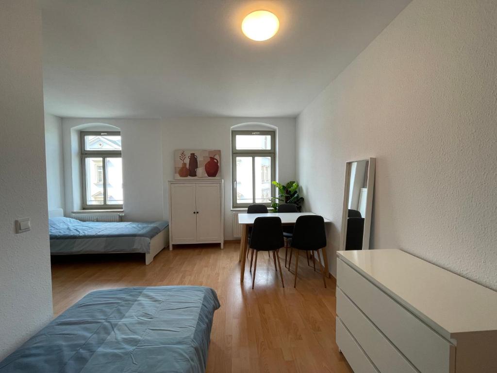 ein Schlafzimmer mit einem Bett, einem Tisch und Stühlen in der Unterkunft Wohnglück Dresden in Dresden