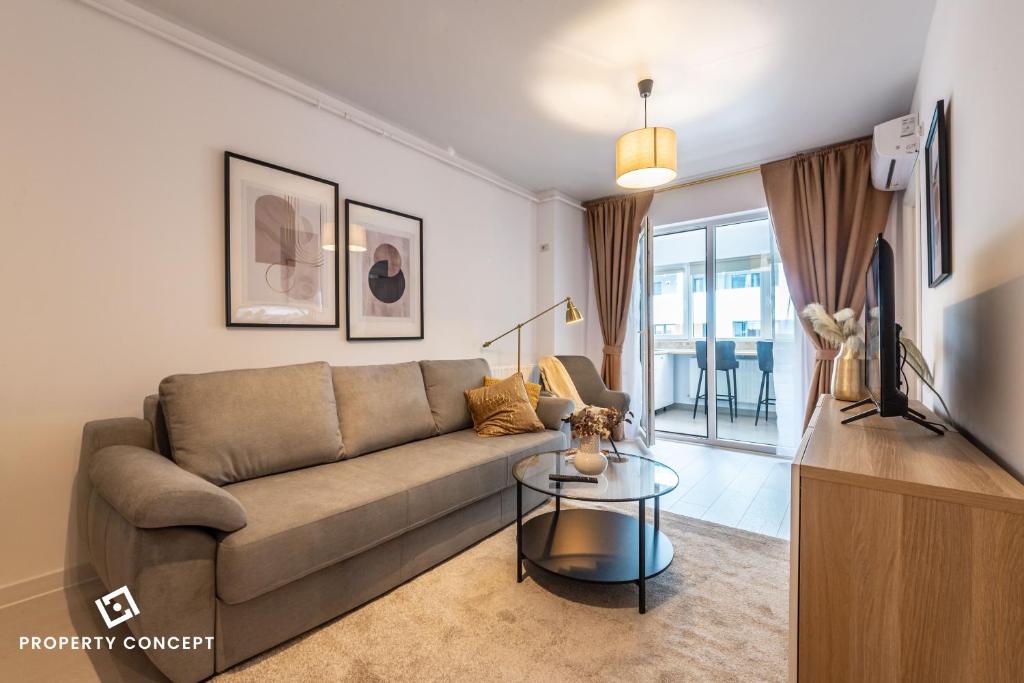 ein Wohnzimmer mit Sofa und Tisch in der Unterkunft Central Residence Apartment 1011 in Vatra Mînăstirii Cotroceni