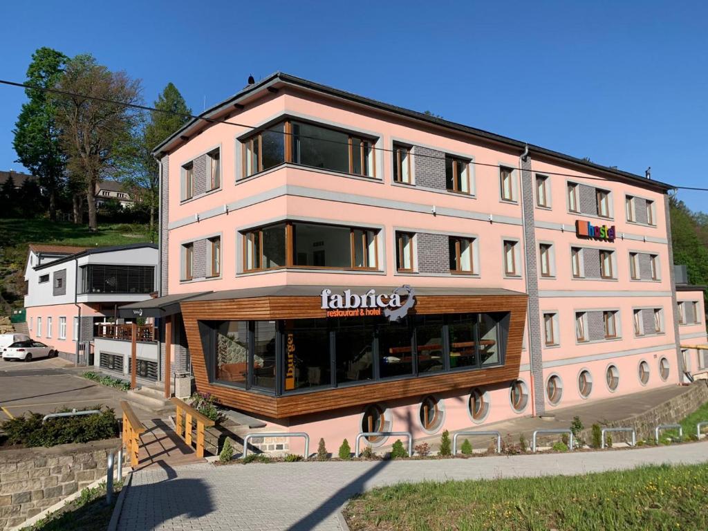 un grand bâtiment rose avec un panneau sur lui dans l'établissement Inter Hostel Liberec, à Liberec