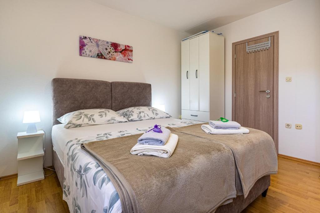 a bedroom with a large bed with towels on it at The Rožolina room in Cres