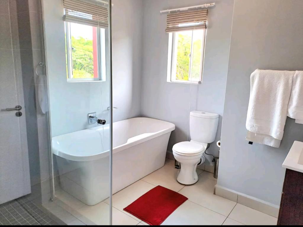 a bathroom with a tub and a toilet and a shower at Cozy Sparrow Hideaway in Sandton