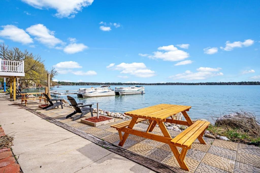 - une table de pique-nique à côté d'un lac avec des bateaux dans l'établissement 3BR Fife Lake Getaway with Fire Pit & Hot Tub, à Fife Lake