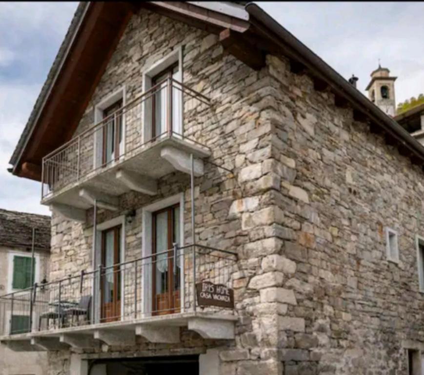 a stone building with a balcony and a clock tower at Iris home in Camblione