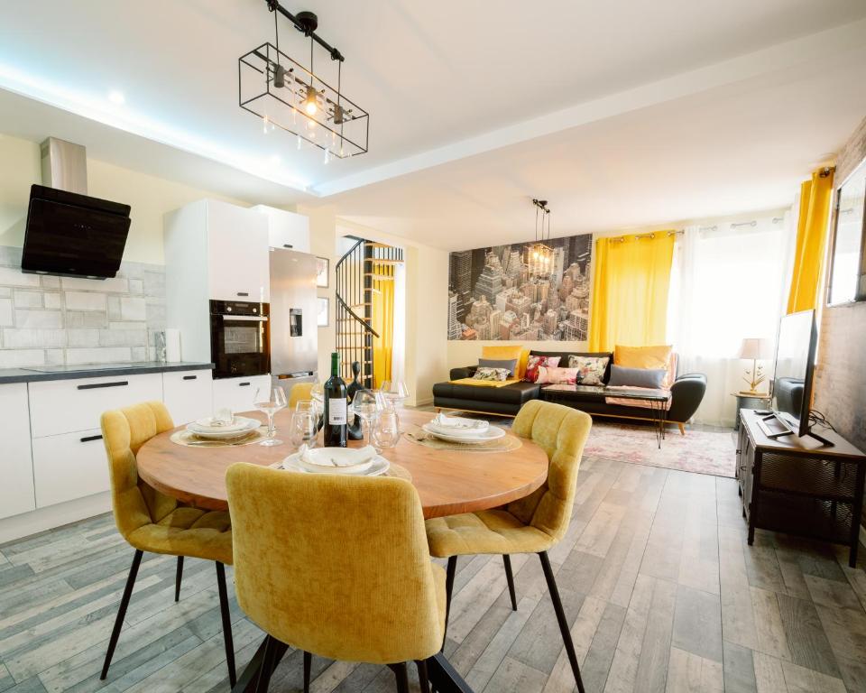 Il dispose d'une cuisine et d'un salon avec une table et des chaises en bois. dans l'établissement Loft Near Basel Airport, à Hésingue