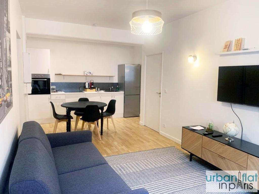 un salon avec un canapé bleu et une table dans l'établissement Urban Flat 167 - Luxury 1 Bedroom Flat in Paris, à Paris