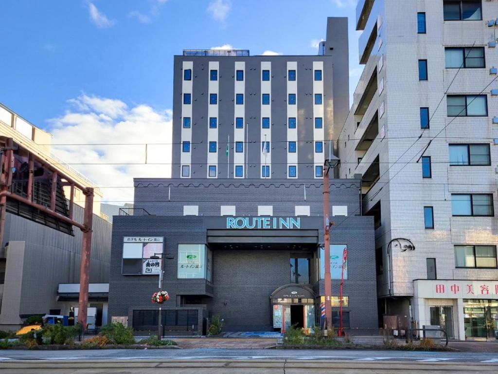 a building with a rollin inn sign in front of it at Hotel Route-Inn Toyama Ekimae in Toyama