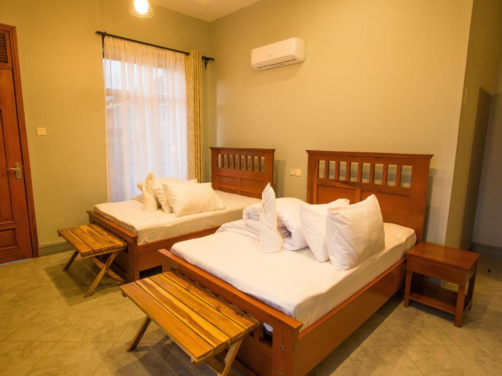 Habitación con 2 camas y ventana en Medan Hotel en Ngateu