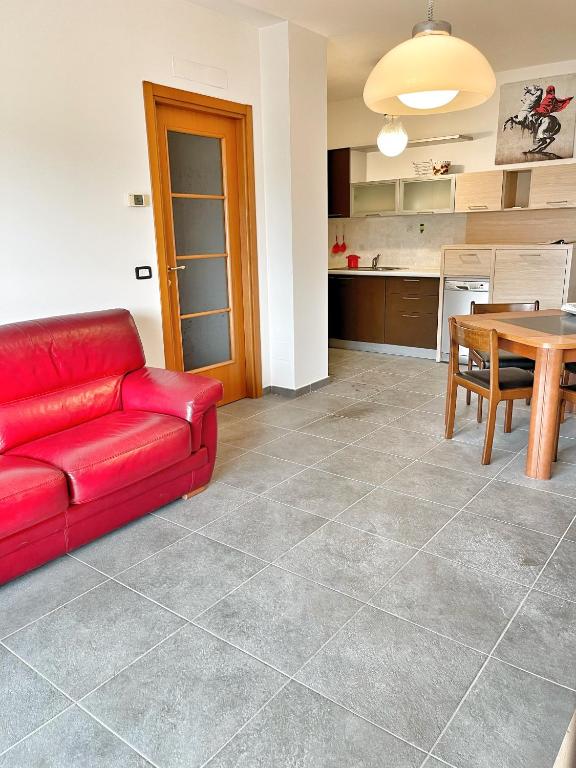 a living room with a red couch and a table at Ville et Mer - tra città e mare in Porto Recanati