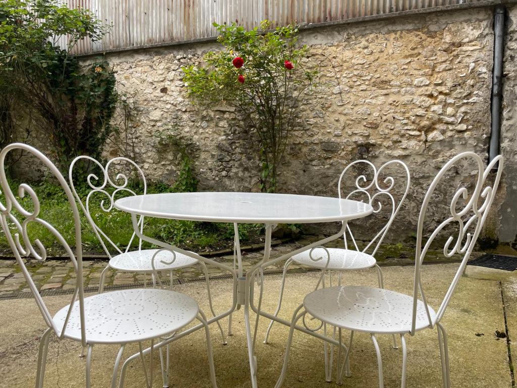 a white table and chairs sitting next to a wall at Studio Saint Ayoul in Provins