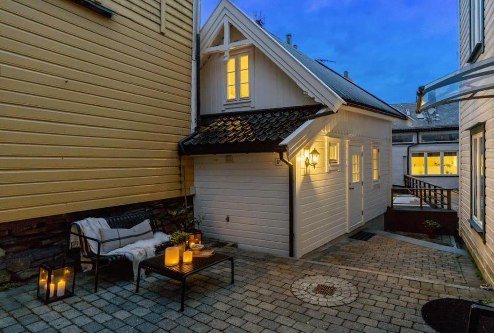 a patio with a table and chairs and a house at Charming Town House in Centrum in Bergen