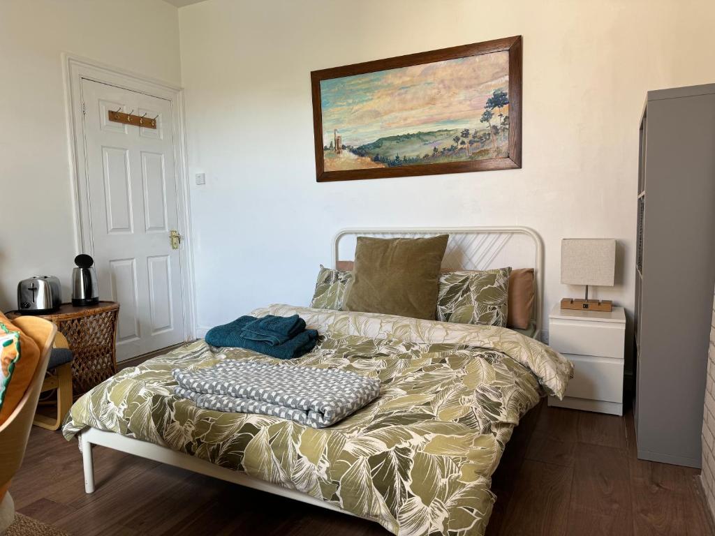 a bedroom with a bed and a painting on the wall at Rectory Cottage in Croydon