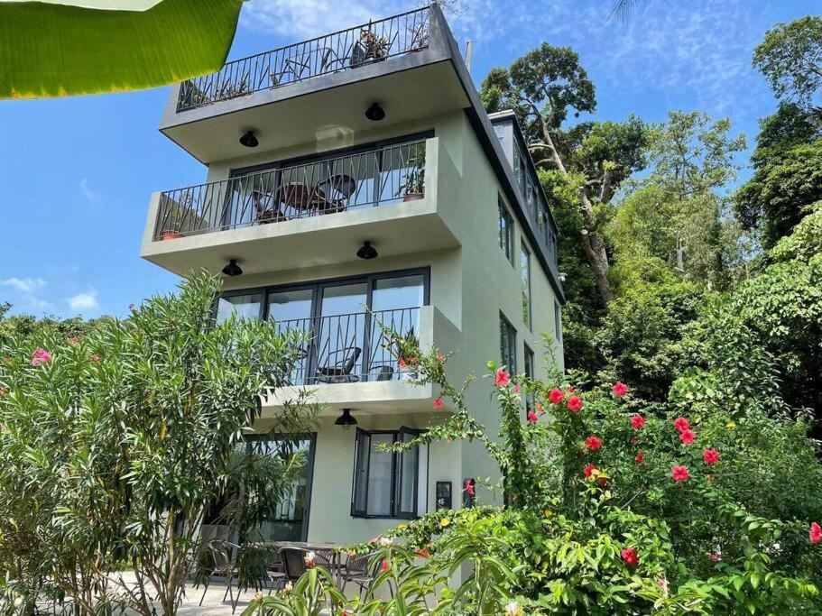 a building with a balcony and some flowers at Holiday Let - Mui Wo, Lantau Island in Hong Kong