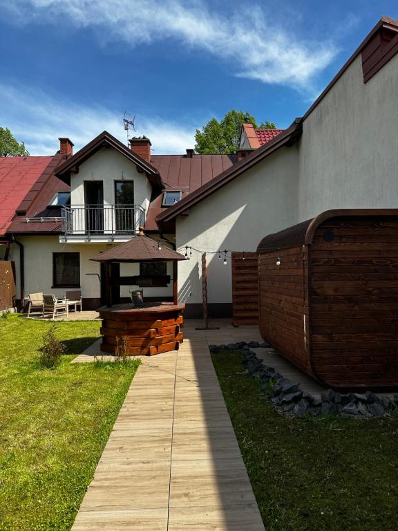einen Hinterhof eines Hauses mit einem Holzsteg in der Unterkunft Chwile w Starym Sączu, sauna i beczka in Stary Sącz