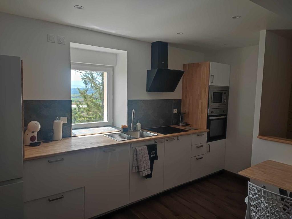 une cuisine avec un évier et une fenêtre dans l'établissement Maison au calme pour 8 personnes à 2 pas du château d Anjou, à Anjou