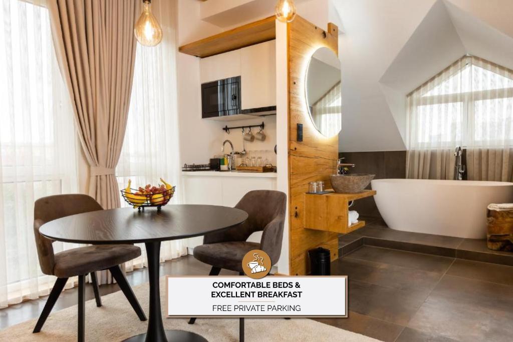 a bathroom with a table and a tub in a room at Kavenija apartmaji - Free Parking in Maribor