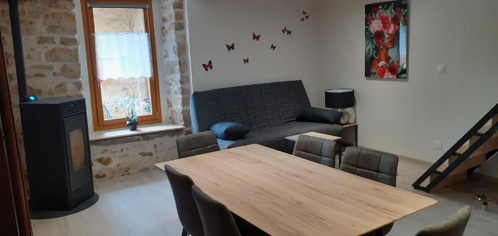 sala de estar con mesa y sofá en Ô JOLi BUGEY en Saint-Rambert-en-Bugey