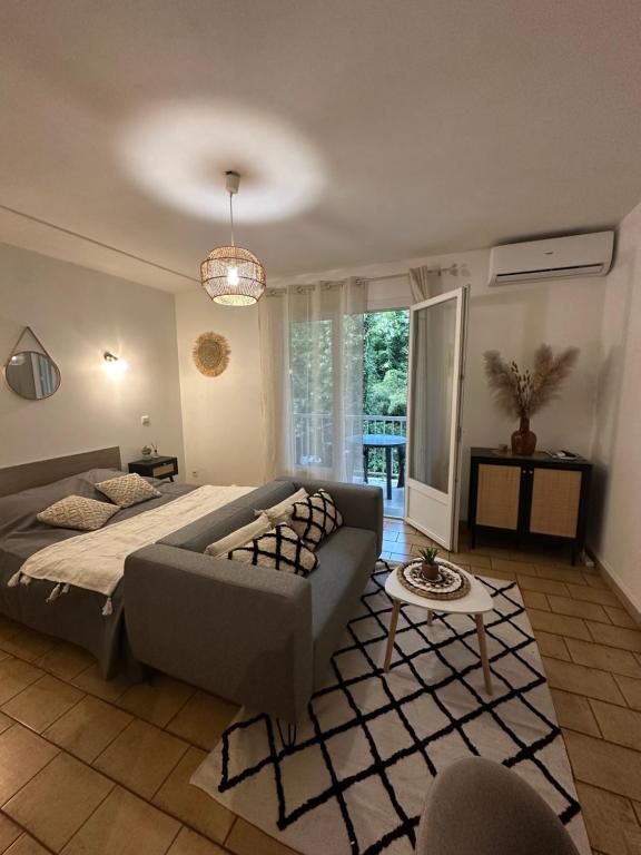 ein Schlafzimmer mit einem Bett und einem Sofa in der Unterkunft Charmant t1 dans le verdon in Gréoux-les-Bains