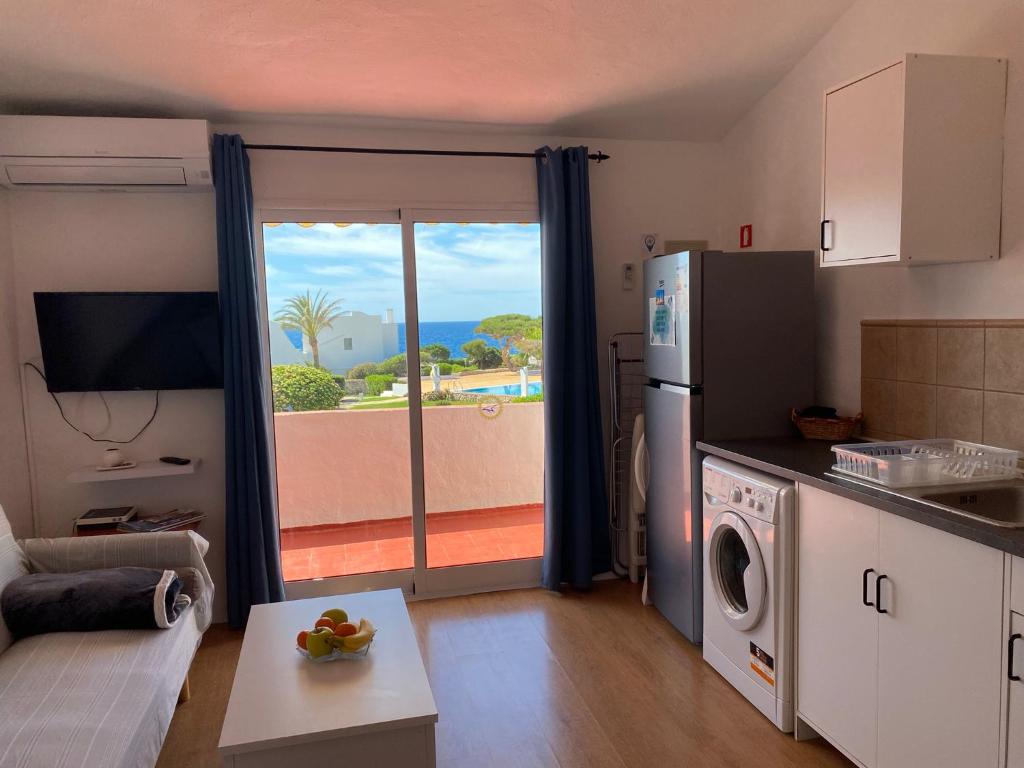 una cucina con frigorifero e vista sull'oceano di Apartamento Bellavista a Cala'n Bosch