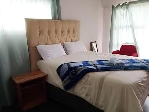 Un dormitorio con una cama grande y una ventana en Run n Fire en Mbabane