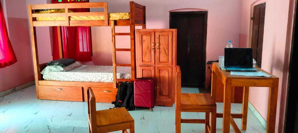 a bedroom with bunk beds and a desk with a laptop at Hostel Gandhi Thiruvananthapuram in Trivandrum