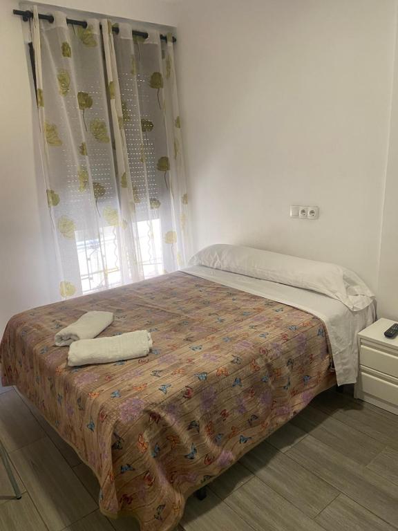 a bedroom with a bed with two towels on it at La Ferroviaria - Habitaciones Con Baño Privado y Compartido - Sin Ascensor in Zaragoza