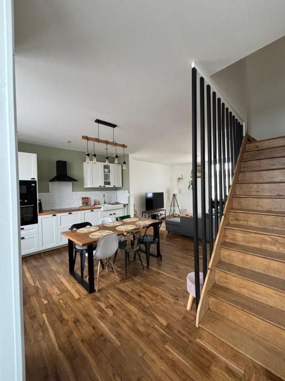 une cuisine et une salle à manger avec une table à manger et une cuisine et des escaliers dans l'établissement La maison des vignes, à Saint-Dizier