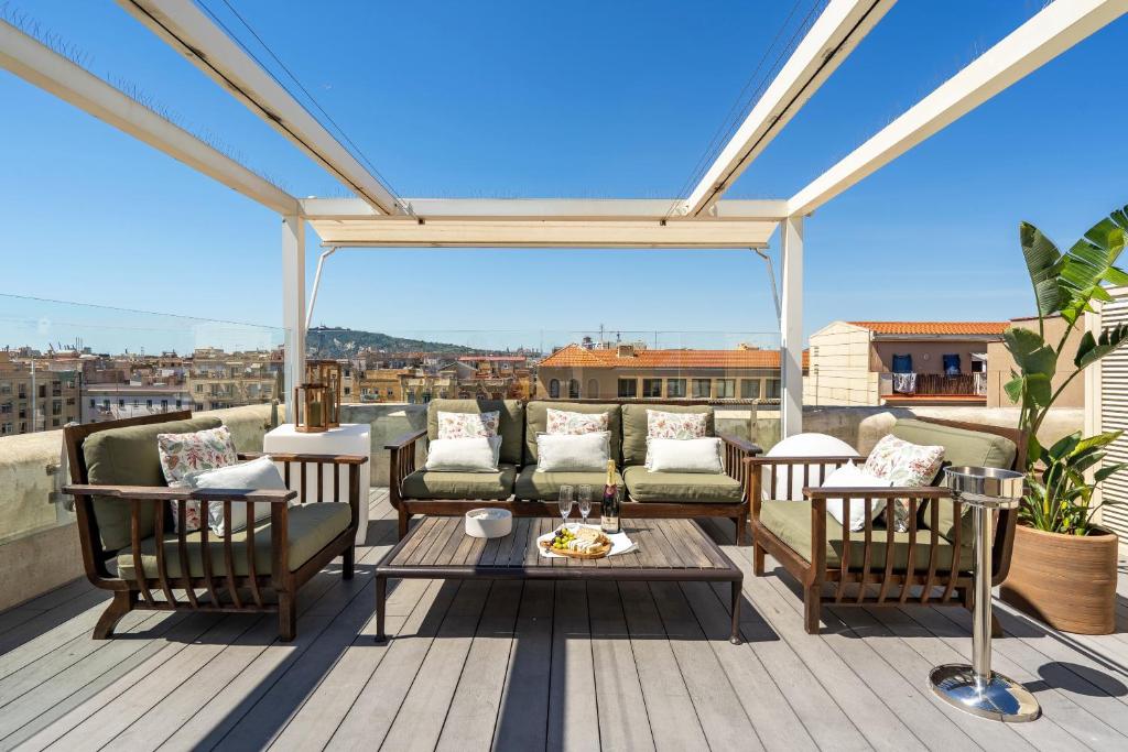 un patio con sillas y una mesa en una terraza en Kronos on the Beach Attic Suite en Barcelona