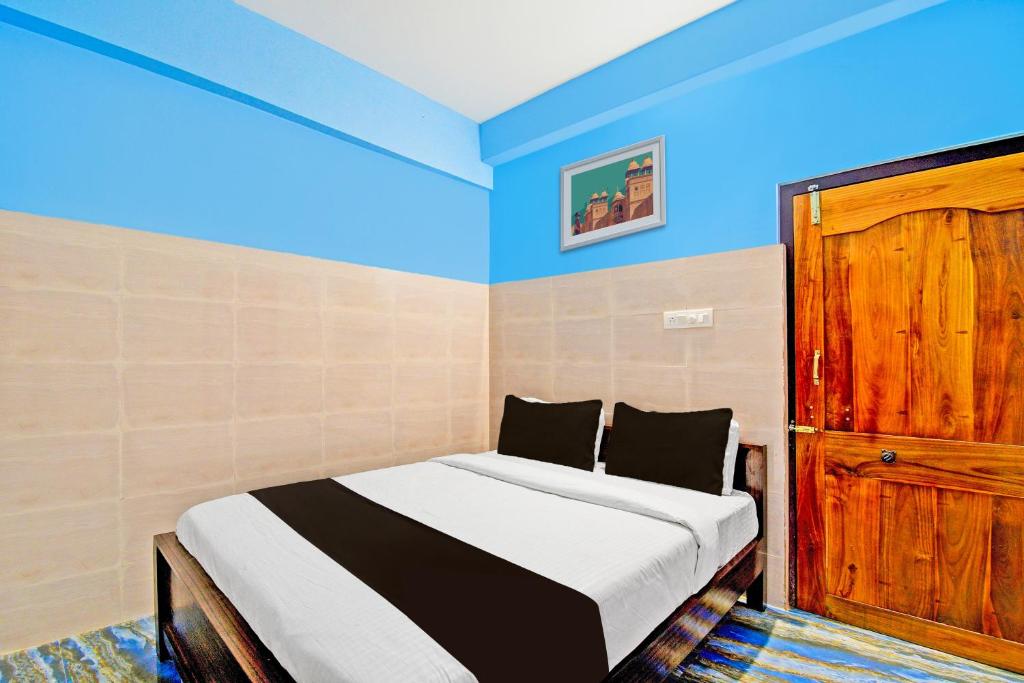 a bedroom with a bed and a wooden door at Flagship City Dreams in Bhubaneshwar