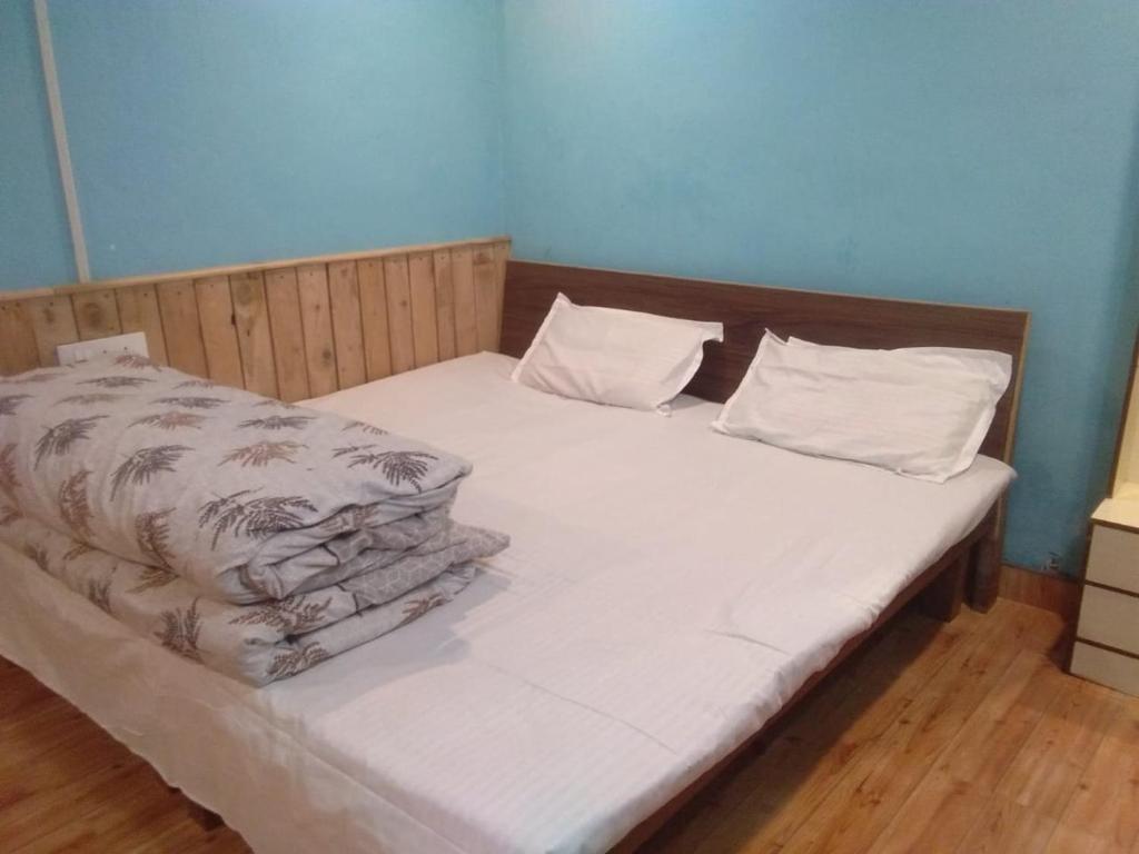 Una cama con sábanas blancas y almohadas. en DS Residency Homestay, Mohana, en Chakrāta