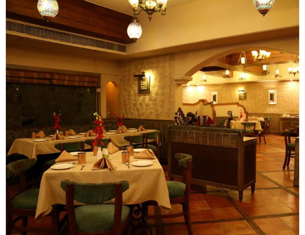 a restaurant with tables and chairs in a room at Hotel Ans International, Raigarh, in Raigarh