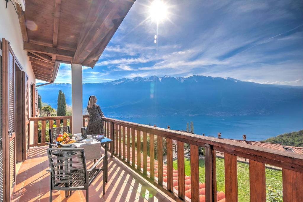 Una mujer parada en un balcón con vista a las montañas. en Balcone sul Lago - Happy Rentals, en Tremosine Sul Garda