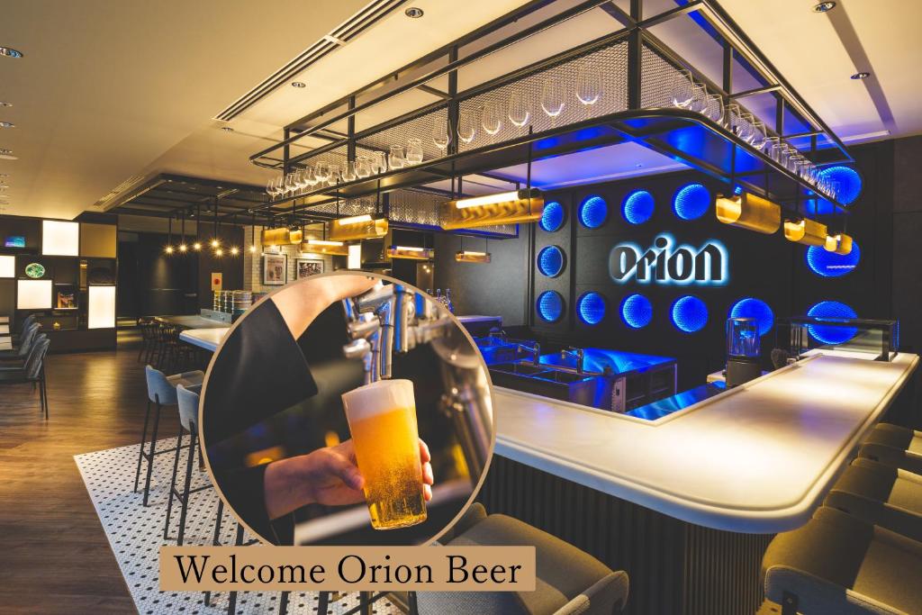 a person holding a glass of beer at a bar at Orion Hotel NAHA in Naha