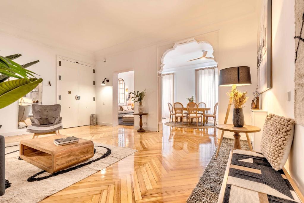 uma sala de estar com mesa e cadeiras em Apartamento Retiro Place II en Madrid em Madri