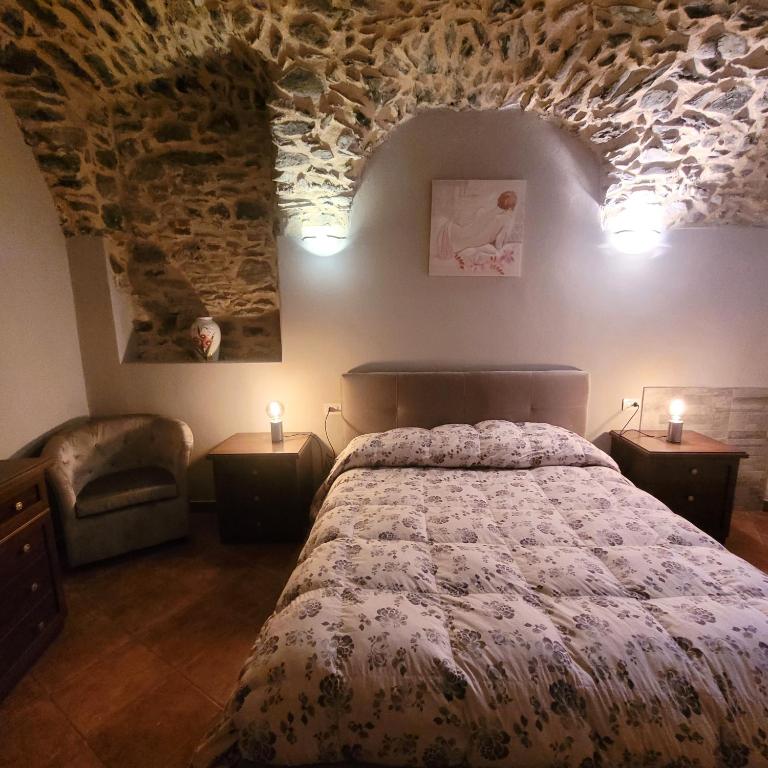 sypialnia z łóżkiem i kamienną ścianą w obiekcie La Casa sull' Altopiano Mountain Lake Iseo hospitality w mieście Bossico