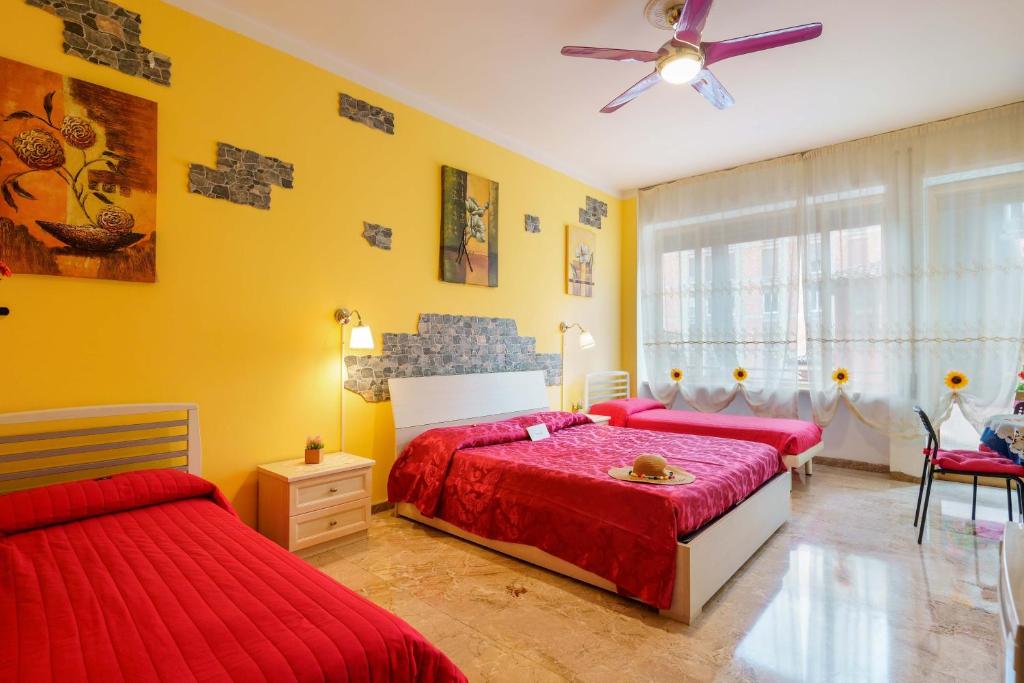 sypialnia z 2 łóżkami i wentylatorem sufitowym w obiekcie Bed and Breakfast Dolce Vita Bologna w Bolonii